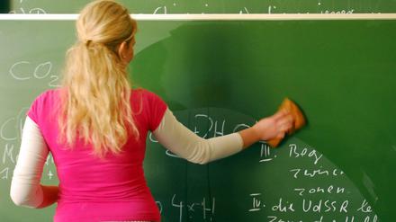 Eine Lehrerin an einer Tafel.
