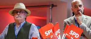 Zwei Männer stehen hinter SPD-Fähnchen im Landtag vor den Räumen der SPD.