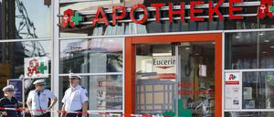 Polizisten stehen vor der Apotheke am Kölner Hauptbahnhof, in der sich am Montag ein Geiselnehmer verschanzt hatte.