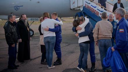 US-Astronaut Nick Hague (Mitte,r) und der russischen Kosmonaut Alexey Ovchinin (Mitte,l) umarmen nach der geglückten Notlandung in Baikonur ihre Angehörigen.