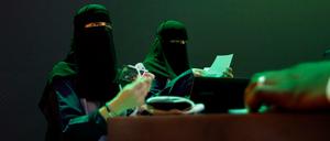 Saudische Mitarbeiter drucken Badges von Teilnehmern der "Future Investment Initiative" Konferenz. 
