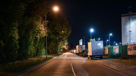 Eine Straße wird im Industriegebiet in Freiburg hinter einem Diskothekenareal nachts von Straßenlaternen erleuchtet.
