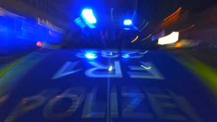 Ein Polizeifahrzeug steht mit Blaulicht auf der Straße.