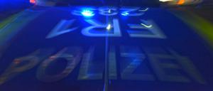 Ein Polizeifahrzeug steht mit Blaulicht auf der Straße.