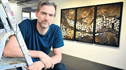 Hendrik Czakainski zeigt seine dreidimensionalen Wandbilder, die an Satellitenbilder erinnern.