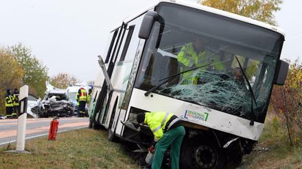Das Wrack eines PKW (l) und ein Schulbus stehen nach einem Unfall auf der Bundesstraße B 107. 