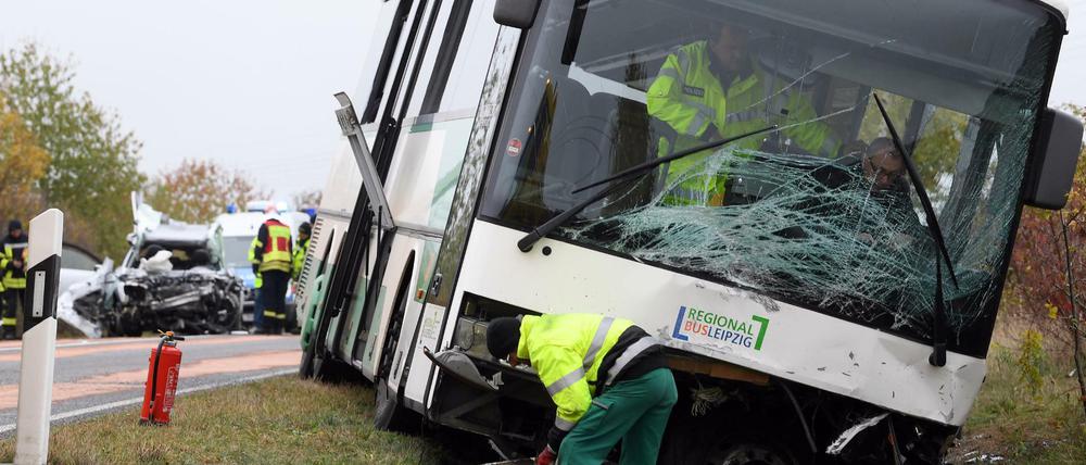 Das Wrack eines PKW (l) und ein Schulbus stehen nach einem Unfall auf der Bundesstraße B 107.