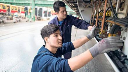 Zwei Flüchtlinge aus Afghanistan reparieren im S-Bahn-Werk in Schöneweide ein Fahrzeug. 
