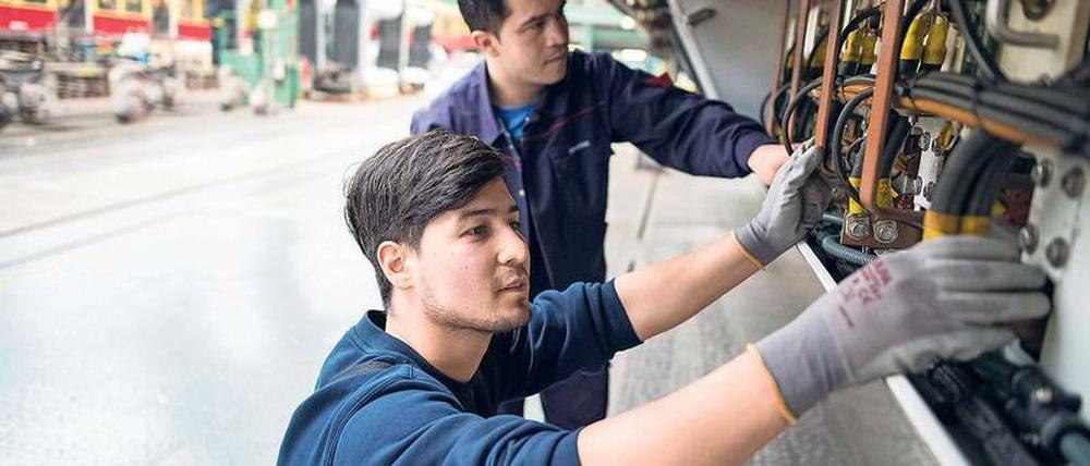 Zwei Flüchtlinge aus Afghanistan reparieren im S-Bahn-Werk in Schöneweide ein Fahrzeug.