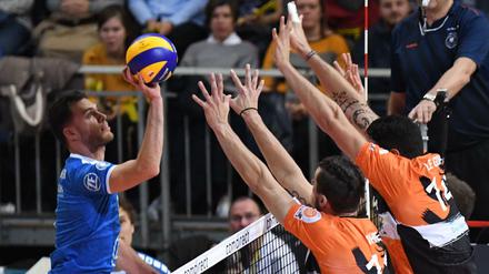 Berlins Adam White und Nicolas Le Goff (r.) und Friedrichshafens David Sossenheimer (l.) kämpfen um den Ball.
