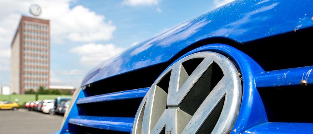 Ein Volkswagenlogo an einem VW Golf vor dem Unternehmenssitz von VW.