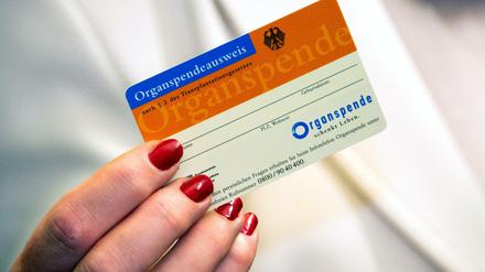 Eine Frau zeigt im Universitätsklinikum Schleswig-Holstein einen Organspendeausweis.