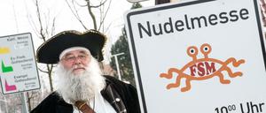 Rüdiger Weida von der «Kirche der fliegenden Spaghettimonster» steht neben seinem Schild «Nudelmesse» in Templin (Brandenburg).
