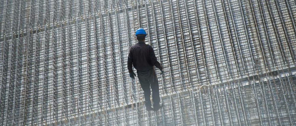 Ein Arbeiter steht auf einer Baustelle im Berliner Hansaviertel.