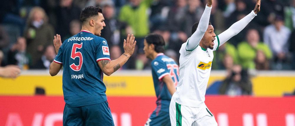 Hände weg: Gladbachs Alassane Plea (r) reklamiert Handspiel von Düsseldorfs Kaan Ayhan (l).