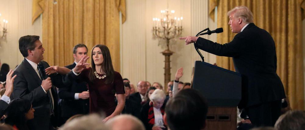 Dreikampf. Während der Auseinandersetzung zwischen CNN-Reporter Jim Acosta (links) und US-Präsident Donald Trump versucht eine Mitarbeiterin des Weißen Hauses, Acosta das Mikrofon wegzunehmen.