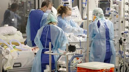 Ärztinnen, Ärzte und Pflegende arbeiten auf der Corona-Intensivstation der Charité am Bett einer Patientin. 