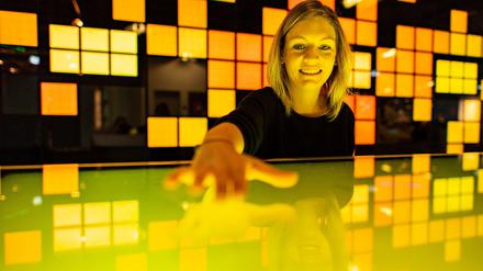 Die Kuratorin der Ausstellung "Künstliche Intelligenz und Robotik" im Heinz Nixdorf-Museums-Forum bedient das Touchpad von einem interaktiven Monitor.