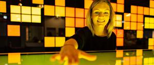 Die Kuratorin der Ausstellung "Künstliche Intelligenz und Robotik" im Heinz Nixdorf-Museums-Forum bedient das Touchpad von einem interaktiven Monitor.