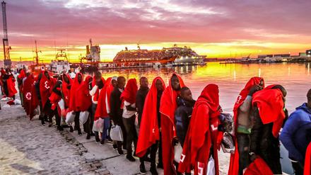 Einwanderer aus Nordafrika stehen am Hafen von Malaga. 