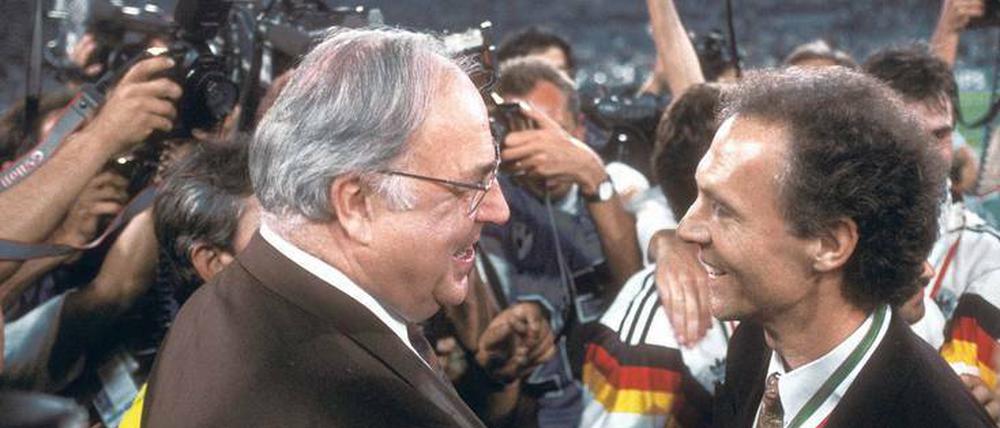 Fast zu viel des Guten für Deutschland. Der Kanzler der Wiedervereinigung gratuliert 1990 dem Weltmeistertrainer. 