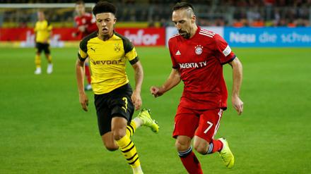 Jadon Sancho (l.) im Laufduell mit Bayerns Franck Ribéry. 