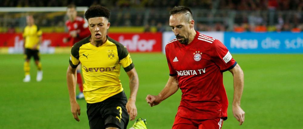 Jadon Sancho (l.) im Laufduell mit Bayerns Franck Ribéry.
