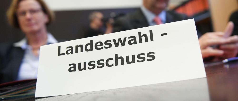 Mitglieder des Landeswahlausschusses sitzen im Sitzungssaal des hessischen Innenministeriums.