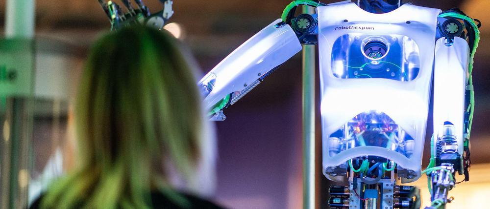Die Kuratorin Judith Spickermann steht in der Ausstellung: "Künstliche Intelligenz und Robotik" im Heinz Nixdorf MuseumsForum vor dem Roboter "robothespian".