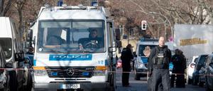 Polizisten sperren eine Straße in der Nähe des Tatortes ab.