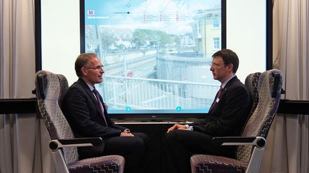 So könnte der Blick aus der Straßenbahn künftig aussehen. Das Institut für Ubiquitäre Mobilitätssysteme (IUMS) an der Hochschule Karlsruhe forscht nicht nur an interaktiven Displays mit Zusatzinformationen als Fenster, sondern auch an der energiesparenden Vernetzung von Verkehrsmitteln. Frank Artinger, Rektor der Hochschule, und Thomas Schlegel, Leiter des IUMS, in der Testumgebung.