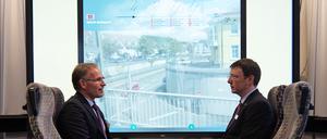 So könnte der Blick aus der Straßenbahn künftig aussehen. Das Institut für Ubiquitäre Mobilitätssysteme (IUMS) an der Hochschule Karlsruhe forscht nicht nur an interaktiven Displays mit Zusatzinformationen als Fenster, sondern auch an der energiesparenden Vernetzung von Verkehrsmitteln. Frank Artinger, Rektor der Hochschule, und Thomas Schlegel, Leiter des IUMS, in der Testumgebung.