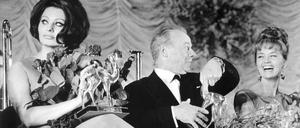 Sophia Loren und Liselotte Pulver, links und rechts von Heinz Rühmann, bei der Bambi Verleihung im Jahr 1964.