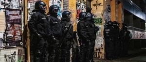 Polizeibeamte stehen bei einer Razzia in der Rigaer Straße in Berlin-Friedrichshain vor einem Haus. 