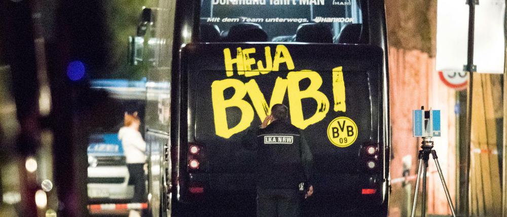 Ein Beamter des Landeskriminalamtes (LKA) untersucht in der Nacht nach dem Anschlag den Mannschaftsbus der Fußballmannschaft von Borussia Dortmund.
