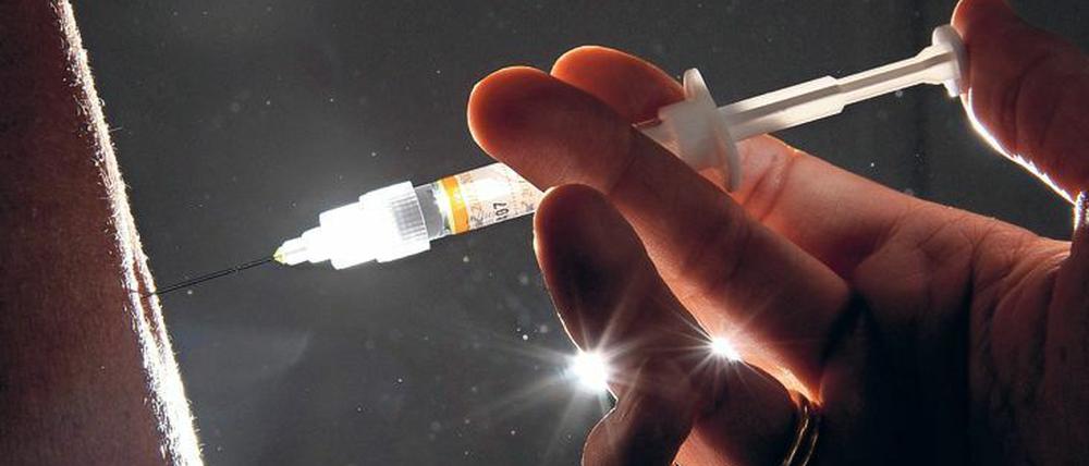 Eine Ärztin spritzt einer Patientin eine Grippeschutzimpfung. 