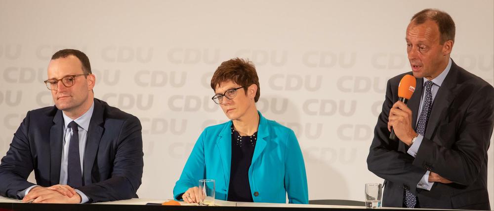 Eine(r) wird gewinnen. Die Kandidaten für Merkels Nachfolge auf Vorstellungstour, Jens Spahn, Annegret Kramp-Karrenbauer und am Mikrofon Friedrich Merz