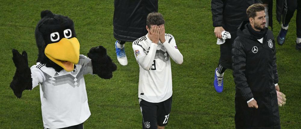 Augen zu und weg. Thomas Müller (M.), Maskottchen Paule und Kevin Trapp verlassen nach dem 2:2 gegen die Niederlande den Platz.