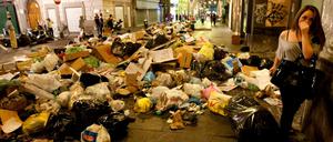 Eine Bewohnerin geht auf dem Höhepunkt der Müllkrise 2011 durch eine Straße Neapels.