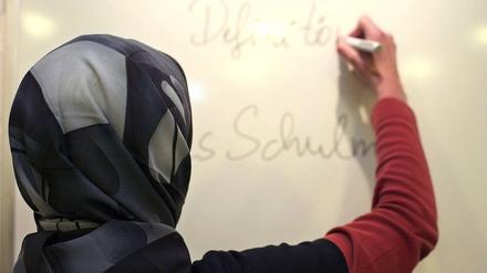 Lehrerin mit Kopftuch in einer deutschen Schule (gestelltes Foto). 