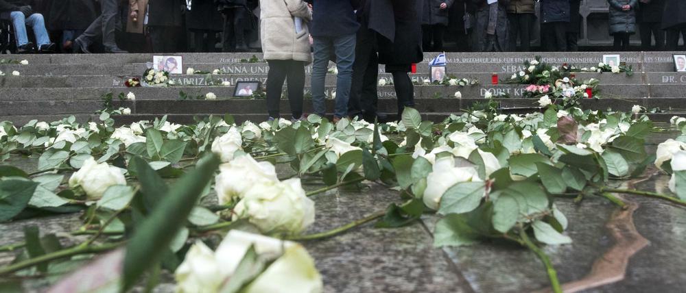 Angehörige legen am 19.12.2017 bei der Einweihung der Gedenkstätte an der Gedächtniskirche auf dem Breitscheidplatz in Berlin Kerzen nieder.