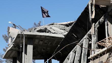 Eine Flagge von Kämpfern des Islamischen Staates ist auf einem zerstörten Haus im syrischen Raqqa zu sehen.