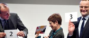 Friedrich Merz (alle CDU,l-r), Annegret Kramp-Karrenbauer und Jens Spahn stehen nebeneinander auf der Bühne und halten Zettel für die Reihenfolge der Vorstellung in der Hand. 