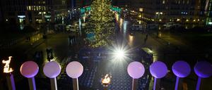 Europas größter Chanukka-Leuchter steht im Gegenlicht eines Scheinwerfers vor dem traditionellen Weihnachtsbaum auf dem Pariser Platz.