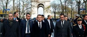 Präsident Emmanuel Macron begutachtet mit Frankreichs Innenminister Christophe Castaner die Schäden der Demonstration der Gelbwesten. 