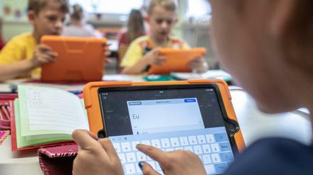 Grundschüler arbeiten mit Tablets.