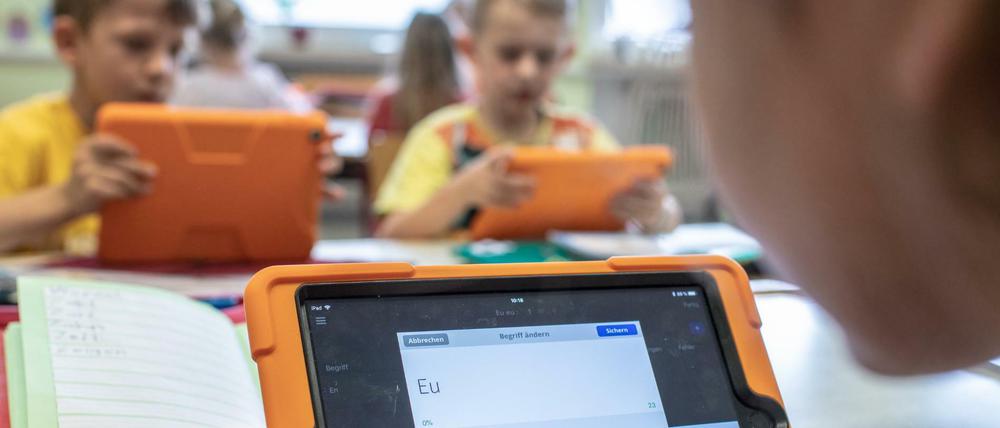 Grundschüler arbeiten mit Tablets.