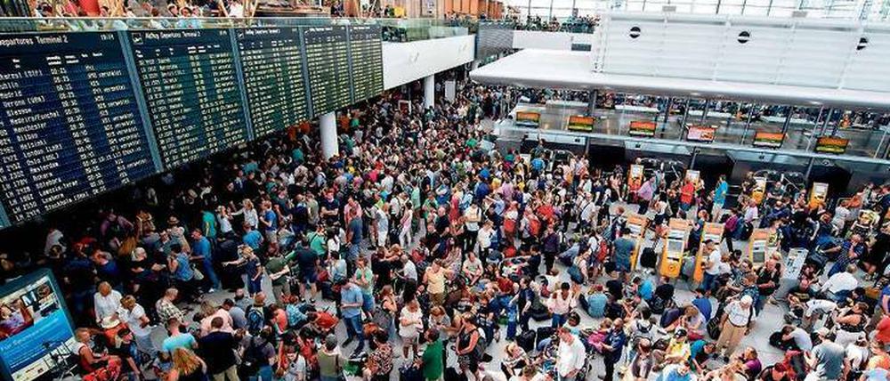 Gestrandet. Lange Menschenschlangen, überfüllte Wartezonen und erschöpfte Passagiere sind an deutschen Flughäfen fast Normalzustand.