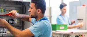 Der 19-jährige Mohammad aus Afghanistan arbeitet im Ausbildungszentrum der Siemens Professional Education an der Verdrahtung eines Schaltschranks. 