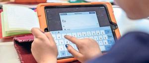 Digitalisierung an der Schule: Grundschüler mit Tablets. 